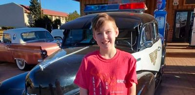 military child standing by cars