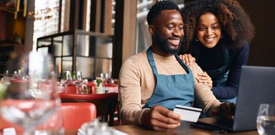 Business Owner on laptop with credit card in hand