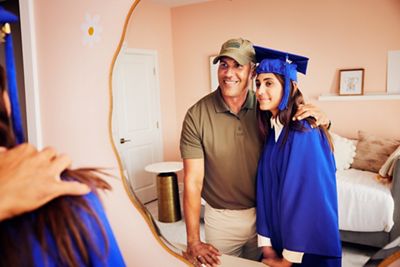 Proud father with graduate daughter looking into a mirror