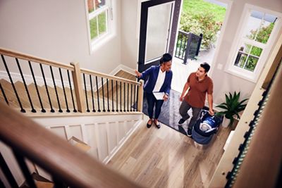 Wide angle shot of Realtor and client entering an open house home