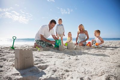 A family spending their time in the beach with lots of fun building sand houses