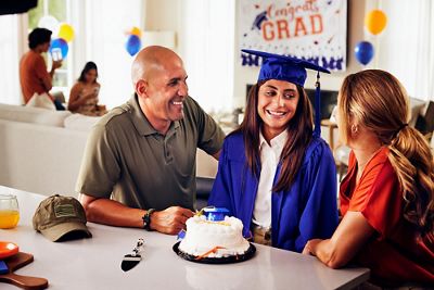 Proud mom and dad sitting with school graduate