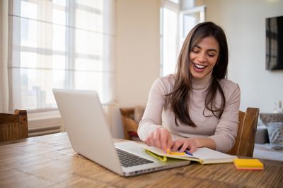 Happy young woman is working from home