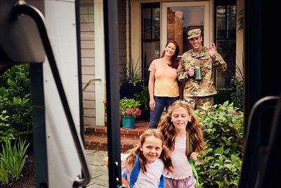 Parents at door sending daughters off to school bus