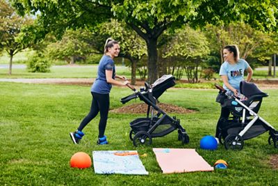 Two women working out while at the park with their babies