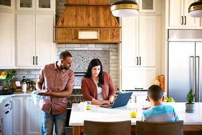 Family online shopping in kitchen at breakfast