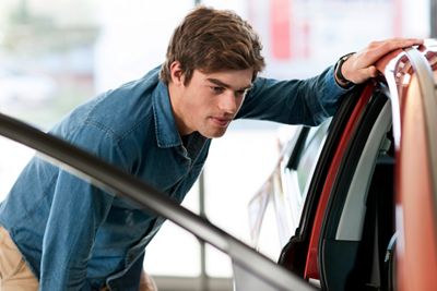 Young man looking into a new car for purchase