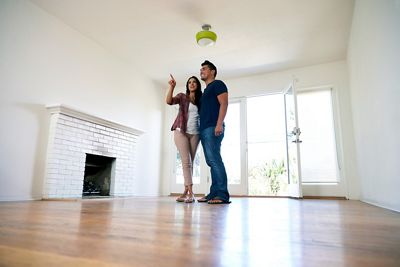 Young couple looking through an empty home for purchasing