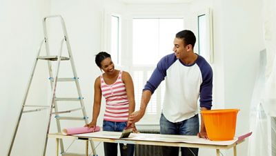 Man and woman preparing to hang wallpaper