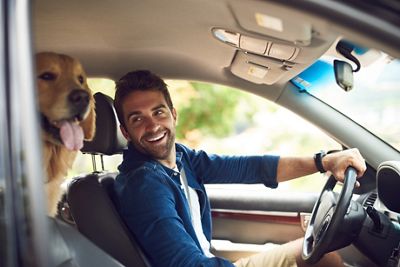 Cropped shot of a handsome young man taking a drive with his dog in the backseat