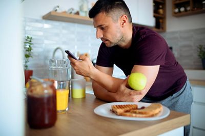 Man reviewing his cell phone while having breakfast