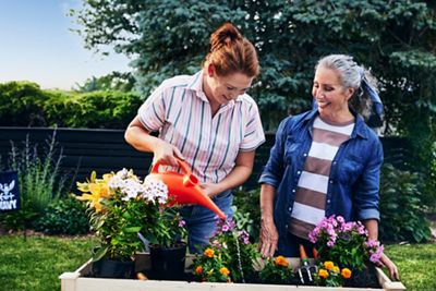 Mother and grown daughter working in the garden