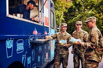 Military comrades receiving their food order from a food truck