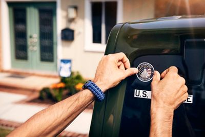 Man adding military sticker to the back of his truck