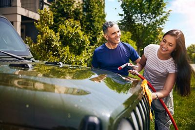 Proud dad watches daughter as she washes her jeep