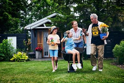 Wide angel of grandparents working in yard with granddaughters